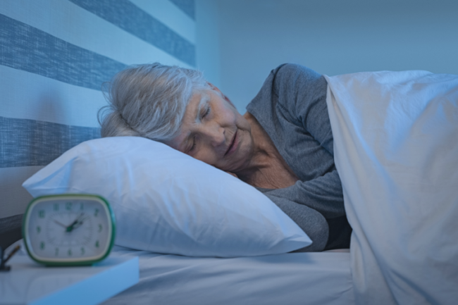 Joint Replacement Importance of Sleep Pre-Surgery and Rehabilitation Older woman sleeping with clock on table