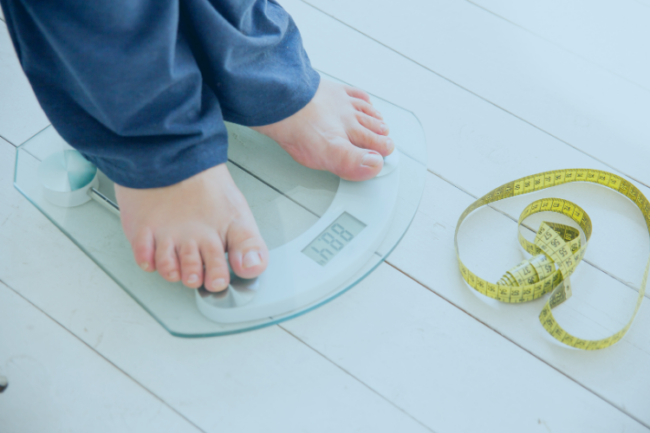 Joint Replacement Outcomes Effect Weight Gain Man on scales with tape measure