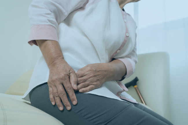 Rheumatoid Arthritis Awareness Hip Older woman sat on bed with hip pain