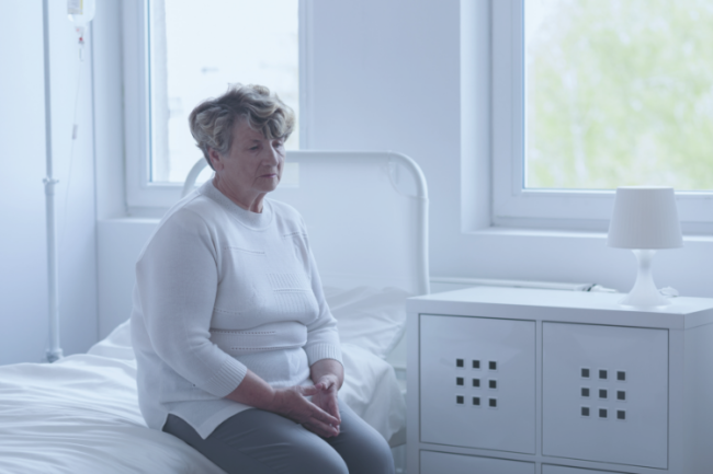 Waiting hip knee replacement Older woman sitting waiting on bed