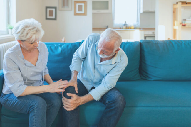 Older man on sofa with knee pain