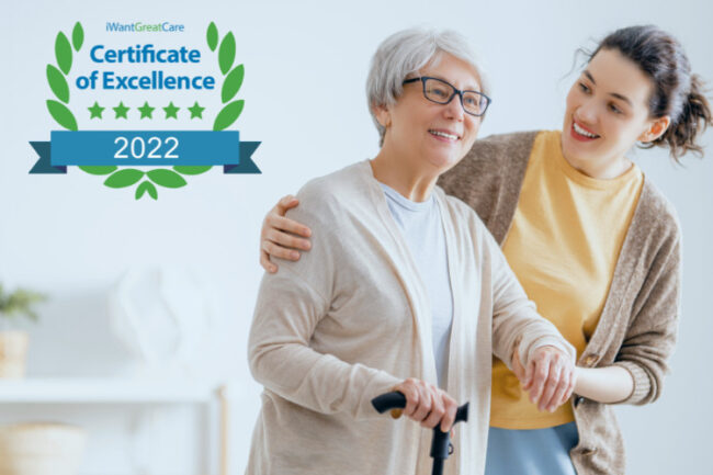 Older woman smiling walking with crutch supported by young woman