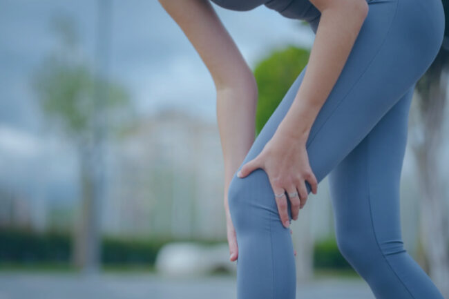 Sporty woman holding her knee