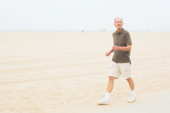 Older man walking on beach