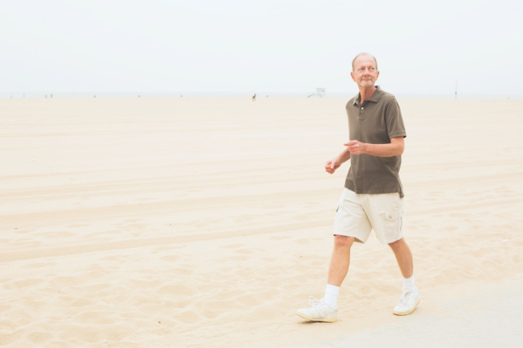 Older man walking on beach