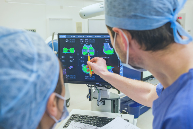 Andrew Carrothers from Carrothers Orthopaedics reviewing a Mako Robotic Arm Assisted Pre-Planning Image of Knee Joint on Screen