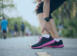 Woman runner holding ankle in pain