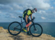 Man on bike holding burning calf muscle in pain