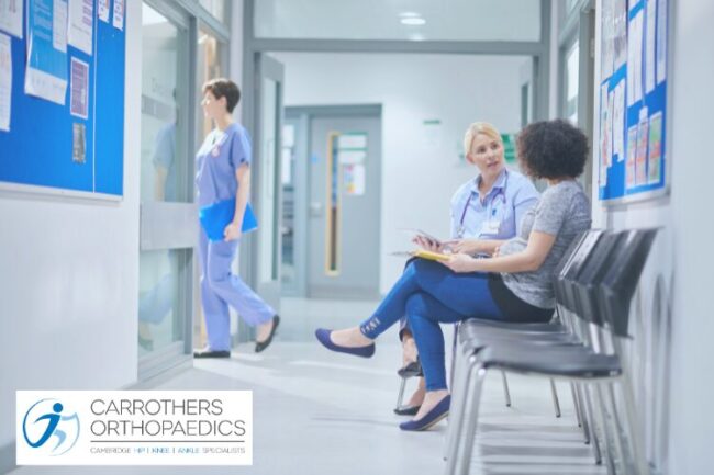 Hospital waiting area with nurse speaking to a patient