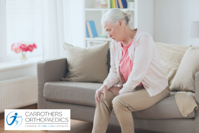 Older woman at home holding knee in pain