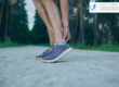Sporty woman wearing trainers holding her Achilles tendon