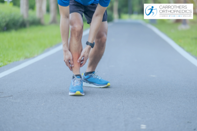 Sports man running holding shin in pain