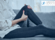 Woman sat on sofa holding her knee