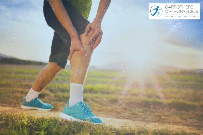 Runner holding the front of his knee whilst out running in the country