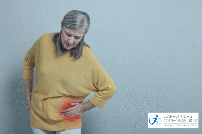 Middle age woman holding her hip in pain
