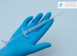 Blue doctors gloved hand holding a needle to administer Arthrosamid for knee osteoarthritis
