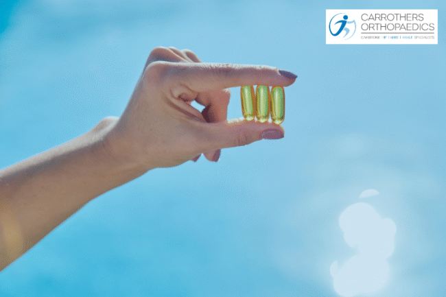 Vitamin D and Joint Replacement Hand holding vitamin D capsules to the sun