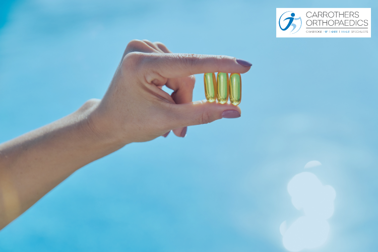 Vitamin D and Joint Replacement Hand holding vitamin D capsules to the sun