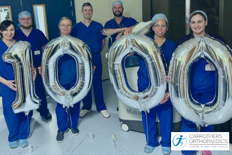 1000 Mako Robotic Arm Assisted Joint Replacements at Carrothers Orthopaedics Andrew Carrothers and the team with 1000 number on balloons