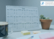 Calendar of 2025 on desk with plant, coffee and post it notes