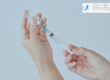 Hands drawing liquid into a syringe