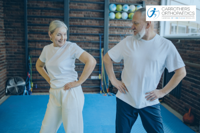 Happy middle age man and women in a fitness studio doing gentle exercise