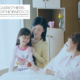 Older woman in a private hospital room with visitors sat on her bed