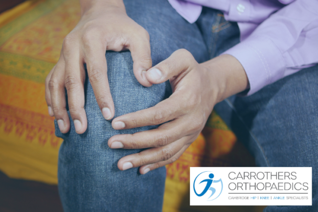 Knee Injuries Understanding Your Treatment Options Man sat on sofa holding his knee