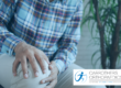 Man sat down holding knee in pain