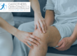 Man sitting down with medical professional assessing his knee
