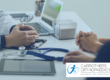 Patient consultant consultation, talking over desk with stethoscope, laptop and tablet
